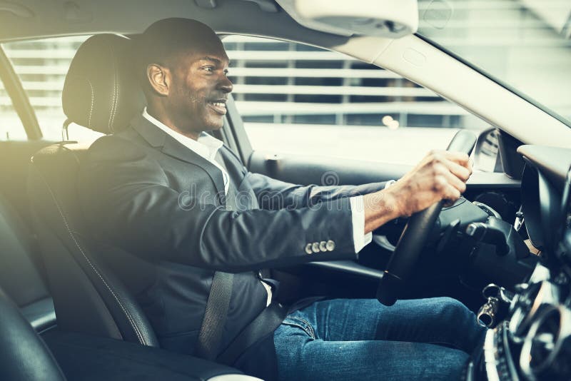 Smiling African businessman driving in the city during his commu