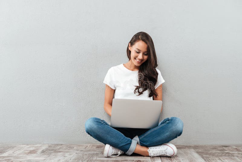 Smiling asian woman typing on laptop computer