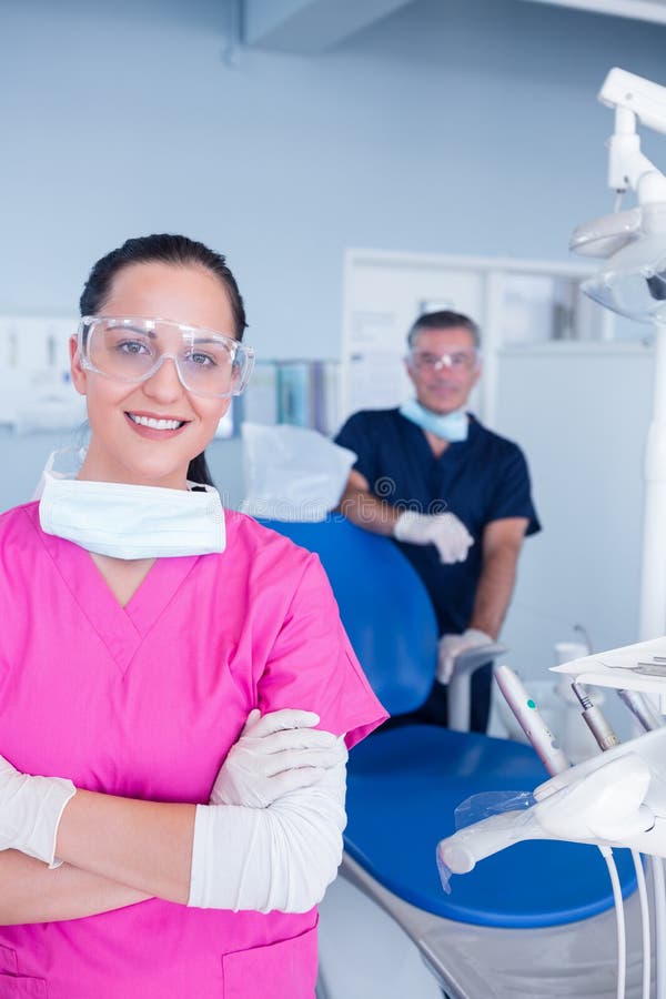 Smiling Assistant And Dentist Behind Her With Protective Glasses Stock Image Image Of Dentists