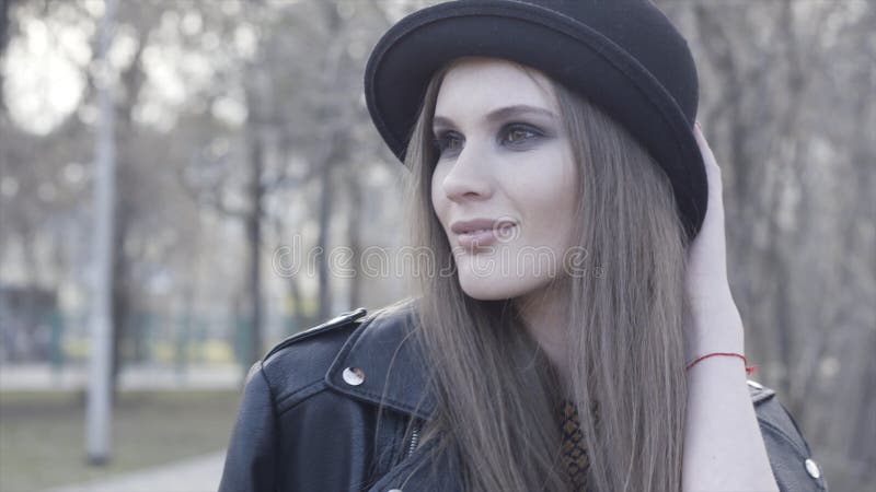 Smiling attractive stylish girl with smoky eyeshadow wearing black hat and leather jacket. Action. Young adorable royalty free stock images Smiling attractive stylish girl with smoky eyeshadow wearing black hat and leather jacket. Action. Young adorable royalty free stock images
