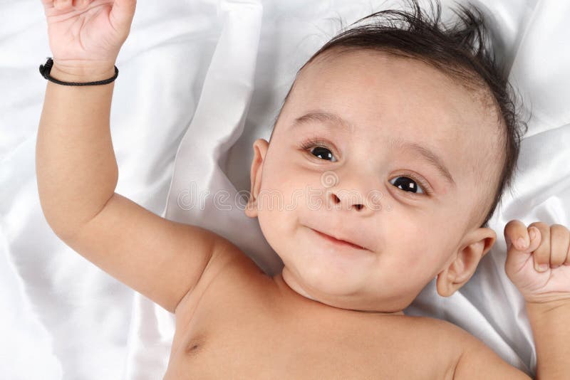 Smiling Baby on white satin stock photography Smiling Baby on white satin stock photography