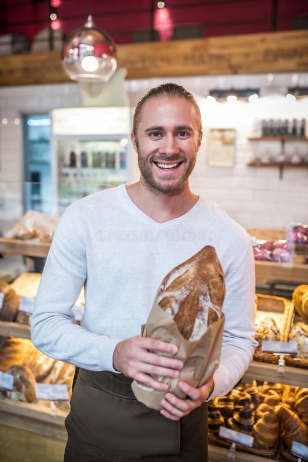Smiling Bearded Man Holding Just Baked Bread Standing in Bakery Stock