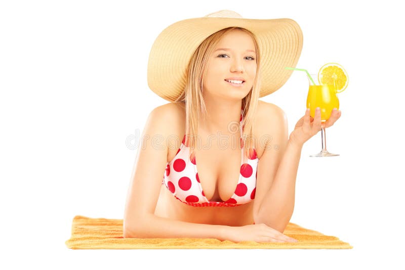 Smiling beautiful female with hat lying on a beach towel and drinking cocktail royalty free stock photo Smiling beautiful female with hat lying on a beach towel and drinking cocktail royalty free stock photo