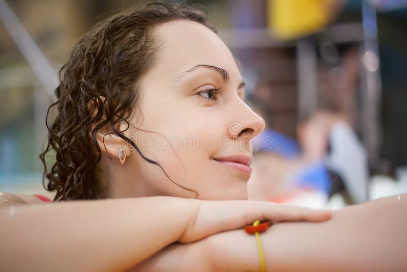 Smiling beautiful woman near ledge in pool stock images