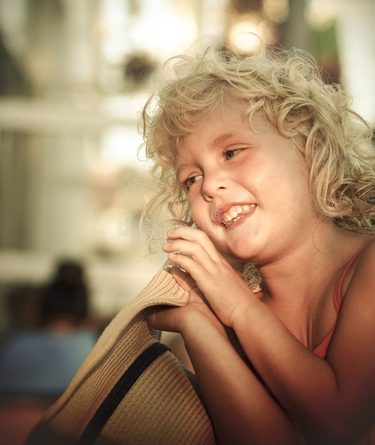 Smiling blond little girl and her big hat