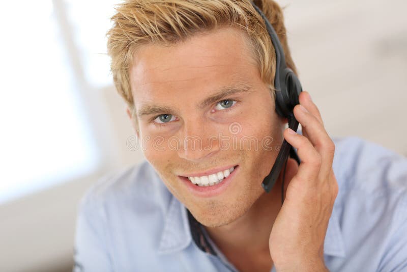 Smiling blond man talking on headset