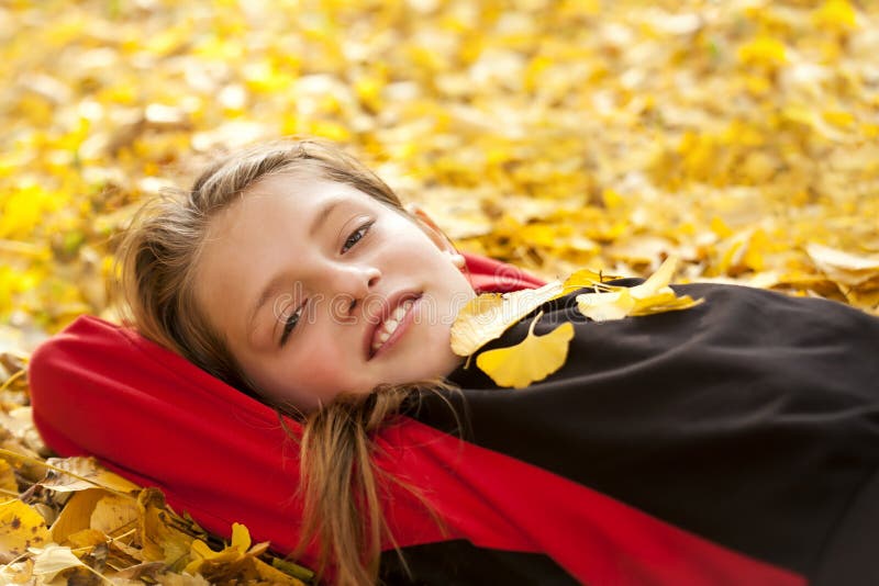 Smiling boy in autumn leaves