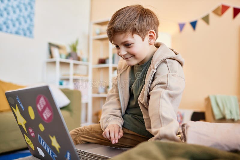 Smiling boy looking at computer screen stock images