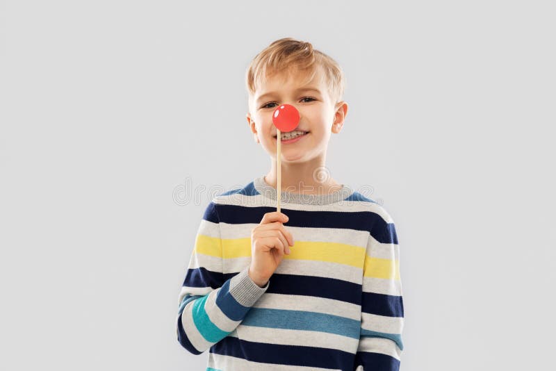 Smiling boy with red clown nose party prop