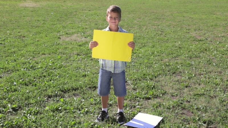 Smiling boy standing with empty blank banner