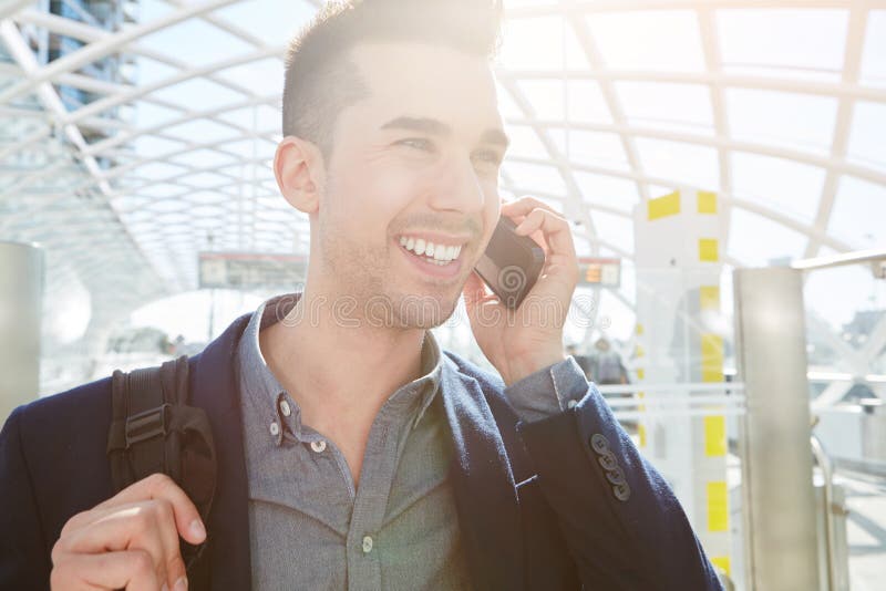 Smiling business man on mobile phone call with bag