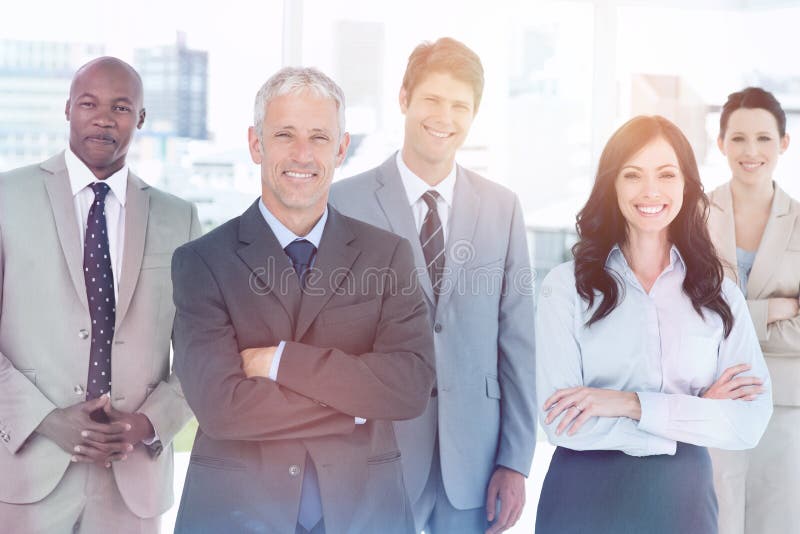 Smiling business team standing in front of a bright window stock images Smiling business team standing in front of a bright window stock images