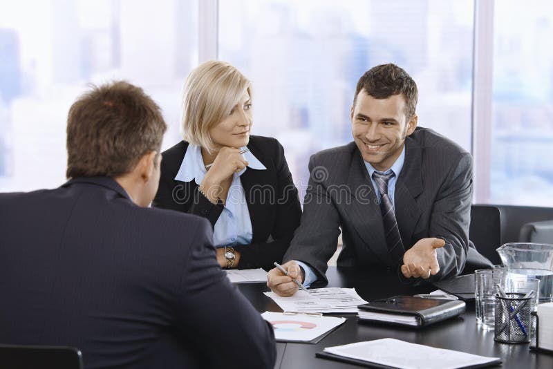 Businessman smiling at meeting stock photography
