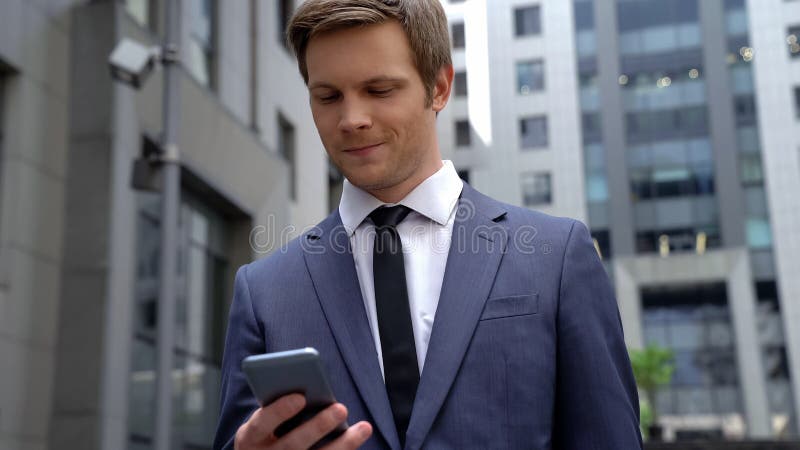 Smiling businessman reading message on smartphone successful investment, startup royalty free stock images Smiling businessman reading message on smartphone successful investment, startup royalty free stock images