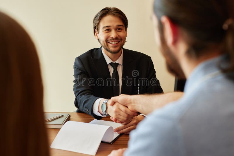 Smiling Businessman Shaking Hands with Client at Office stock photo