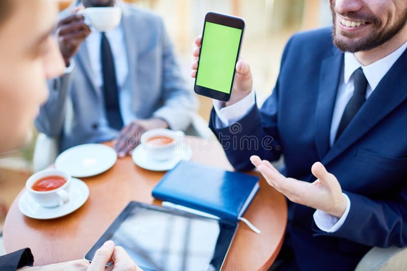 Smiling Businessman Showing Mobile Application on Phone royalty free stock photography