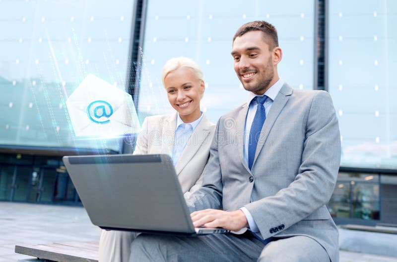 Smiling businesspeople with laptop sending e-mail royalty free stock photo Smiling businesspeople with laptop sending e-mail royalty free stock photo