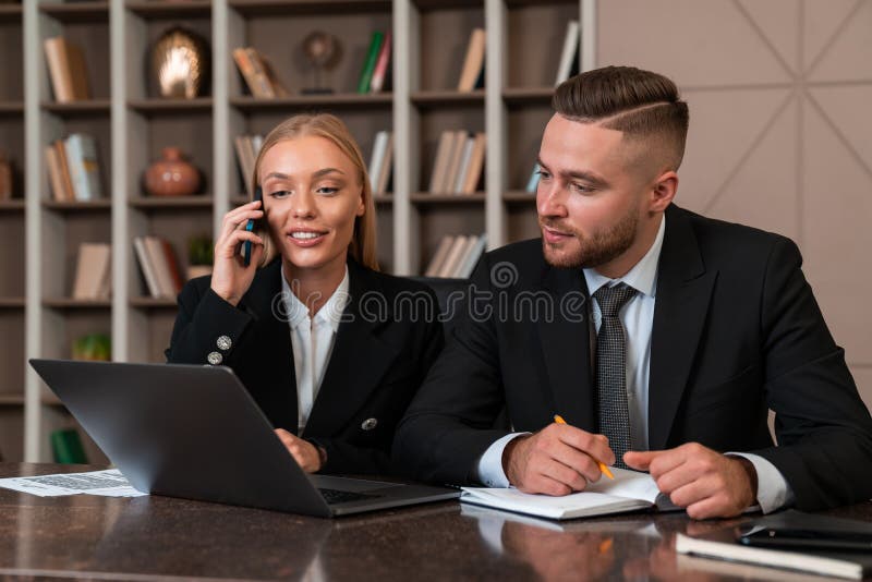 Smiling businesswoman call and businessman taking note in office room royalty free stock photo
