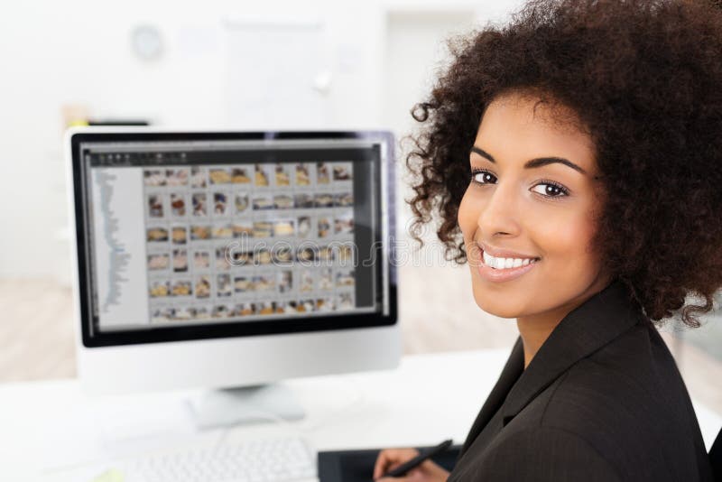 Smiling businesswoman editing photographs stock images