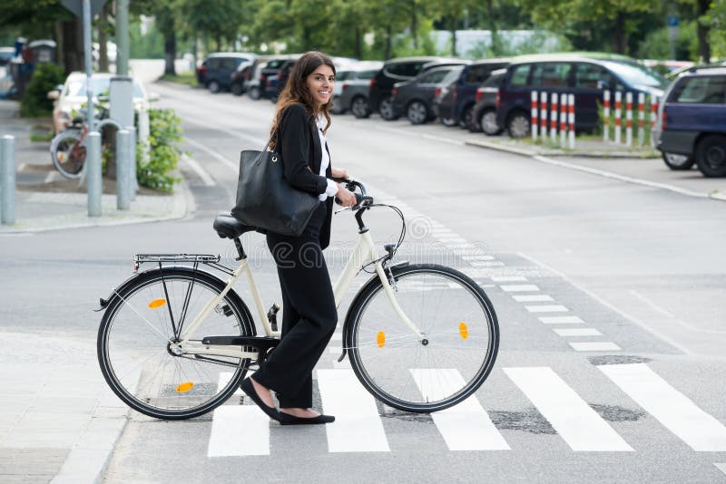 Smiling Businesswoman With Handbag Commuting On Bicycle stock photography Smiling Businesswoman With Handbag Commuting On Bicycle stock photography
