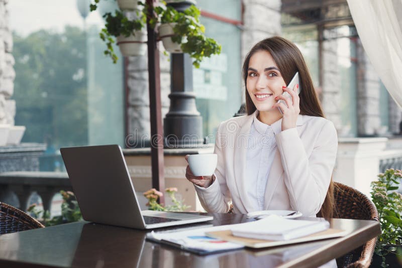 Young woman talking on phone and drinking coffee stock image Young woman talking on phone and drinking coffee stock image