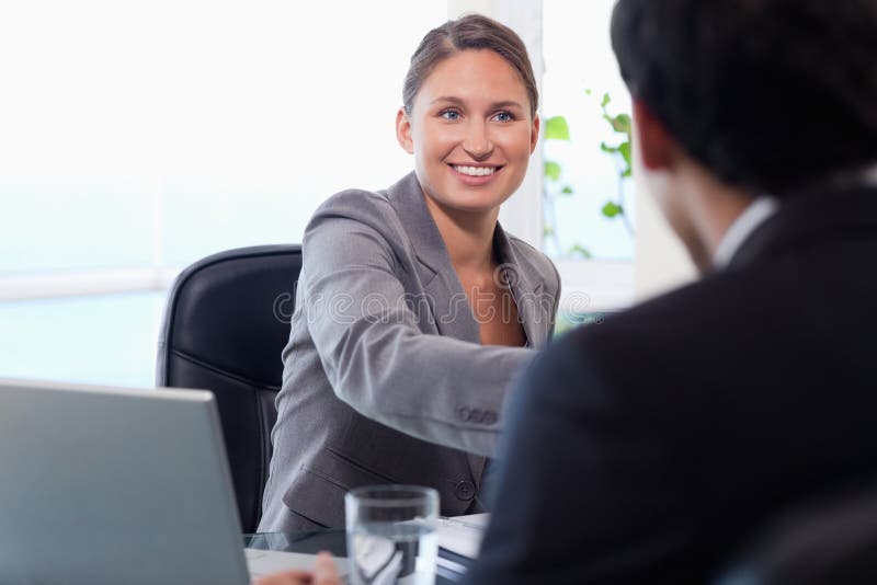 Smiling businesswoman welcomes customer stock images