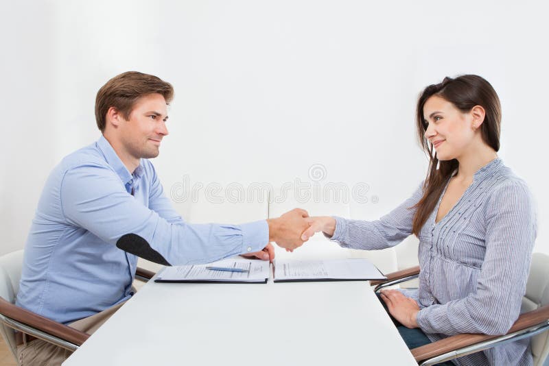 Smiling candidate shaking hand with businessman. Smiling female candidate shaking hands with businessman in office royalty free stock photo Smiling candidate shaking hand with businessman. Smiling female candidate shaking hands with businessman in office royalty free stock photo