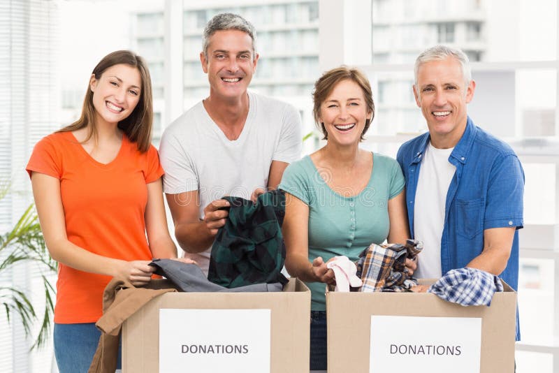 Portrait of smiling casual business people sorting donation boxes in the office. Charity sorting stock images, royalty-free photos and pictures