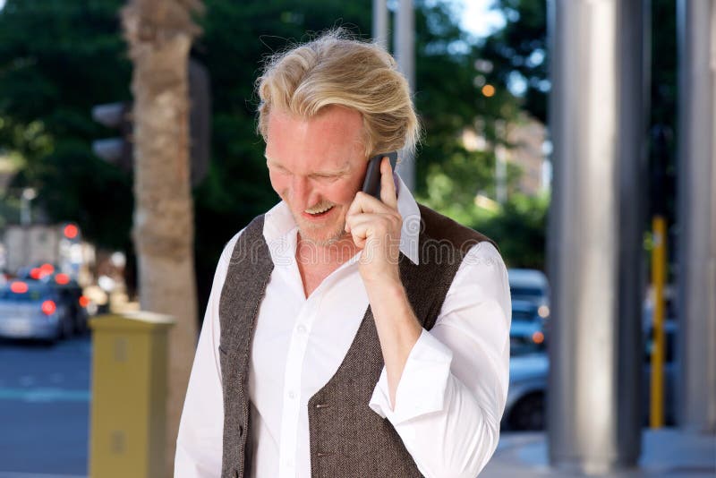 Smiling caucasian man on the city street talking on mobile phone royalty free stock images Smiling caucasian man on the city street talking on mobile phone royalty free stock images