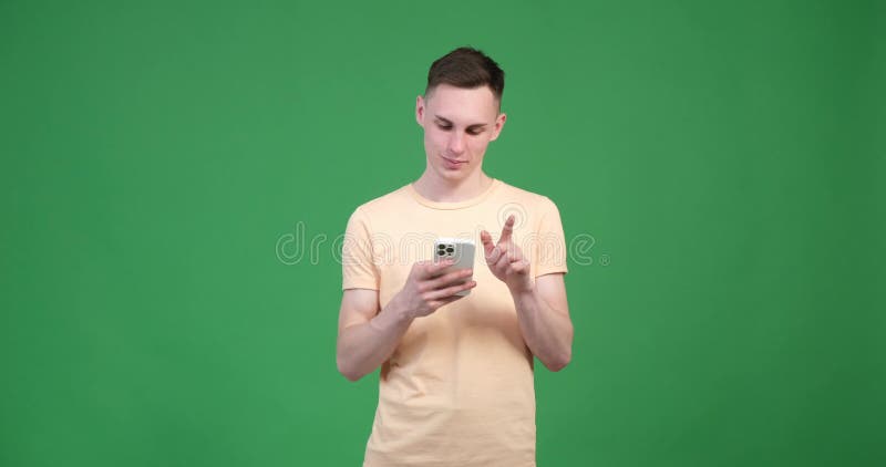 Bărbat caucazian zâmbitor care se plimbă la telefon pe un fond verde stock video