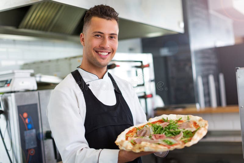 Smiling Chef Holding Fresh Pizza in Kitchen Stock Photo - Image of ...