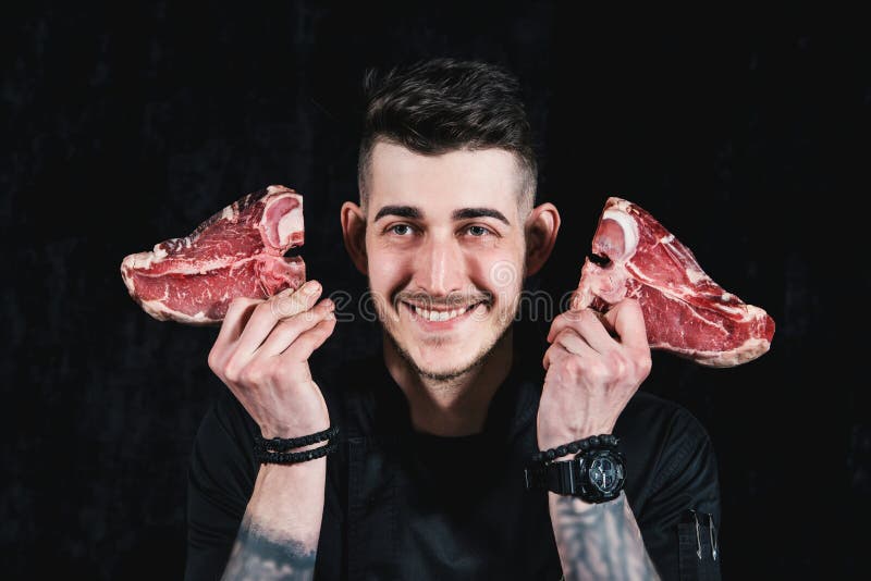 Smiling Chef Plays with Raw Meat Steaks. Closeup in the Kitchen Stock Photo Image of holding