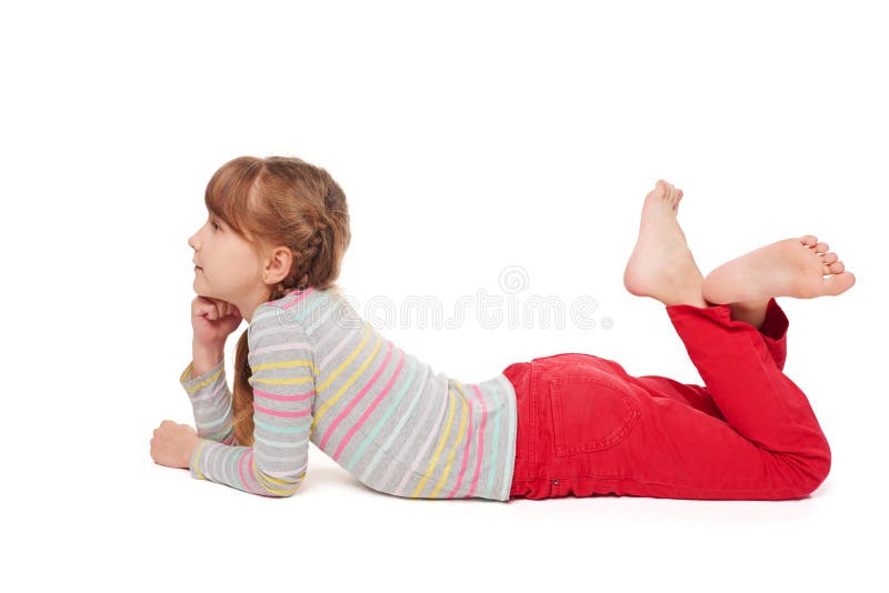 Smiling child girl lying on stomach on the floor