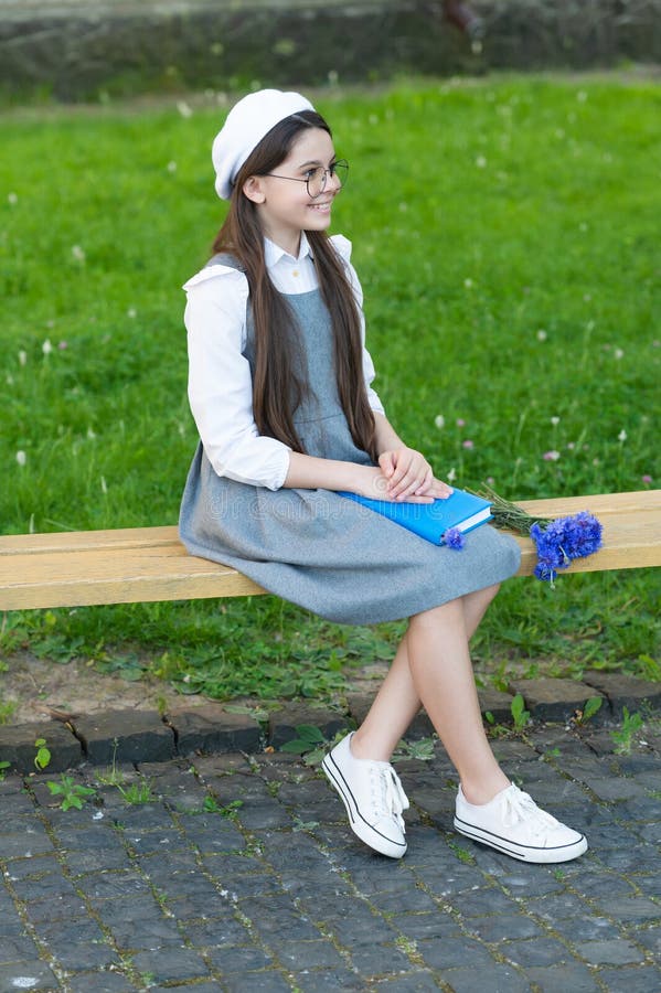 Smiling Child in Glasses Relax on Park Bench with Book Stock Photo