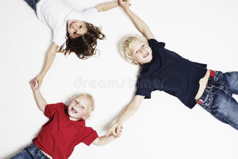 Smiling children on floor holding hands
