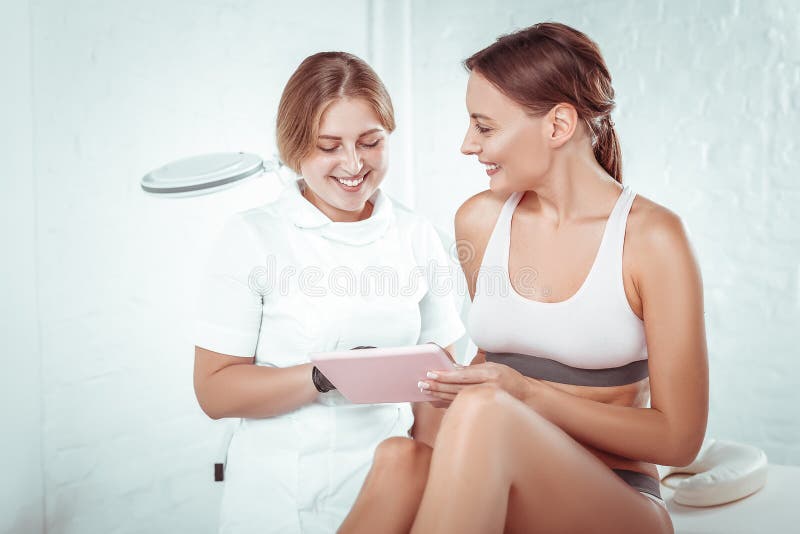 Smiling cosmetologist in a white uniform and black gloves royalty free stock photos Smiling cosmetologist in a white uniform and black gloves royalty free stock photos