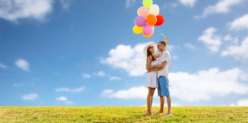 Smiling couple with balloons over sky and grass royalty free stock image Smiling couple with balloons over sky and grass royalty free stock image