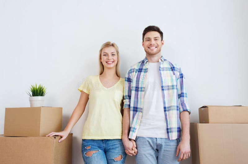 Smiling couple with big boxes moving to new home. Copyspace, blank.