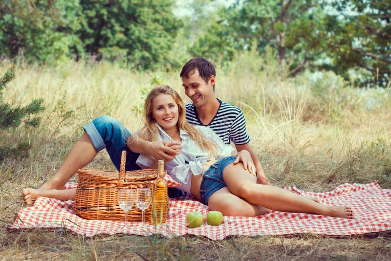Smiling couple have rest in wood on picnic