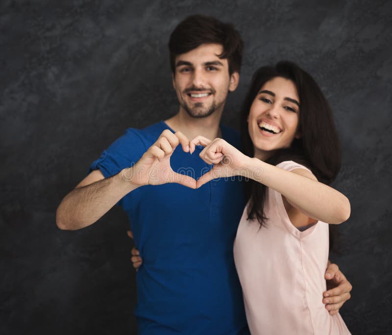 Smiling couple making heart shape by fingers stock images Smiling couple making heart shape by fingers stock images