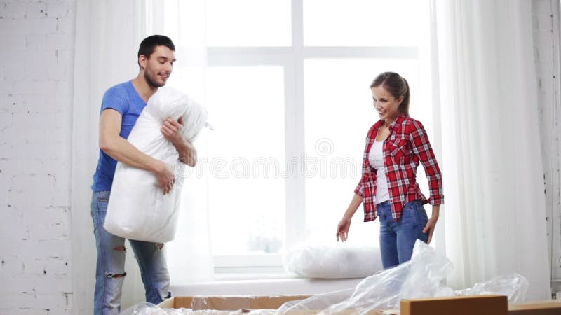 Smiling couple opening big cardboard box with sofa