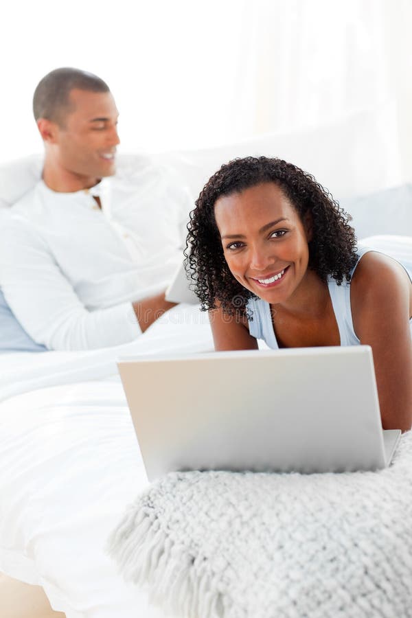 Smiling couple relaxing on their bed at home