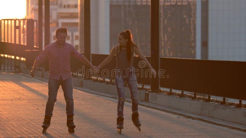 Smiling couple on rollerblades.