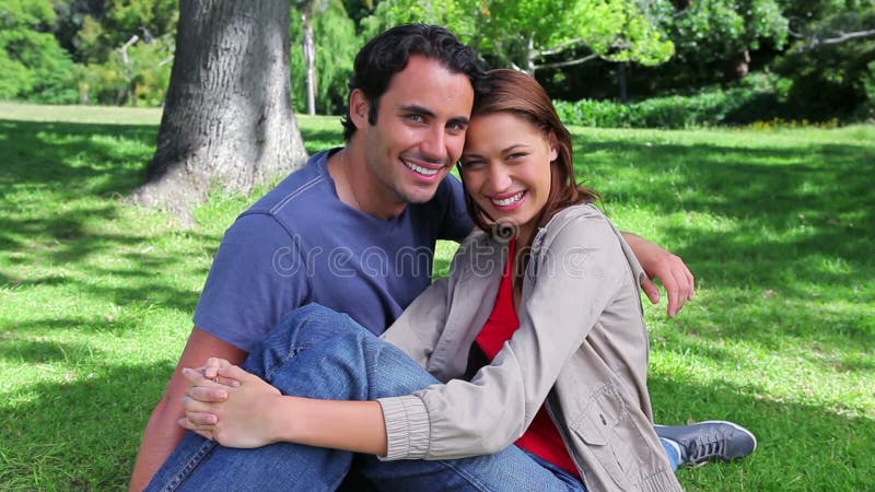 Smiling couple sitting on the grass
