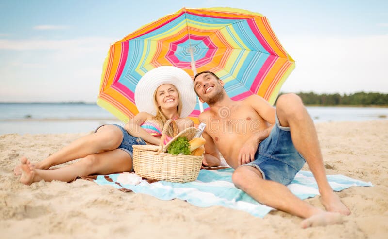 Smiling couple sunbathing on the beach