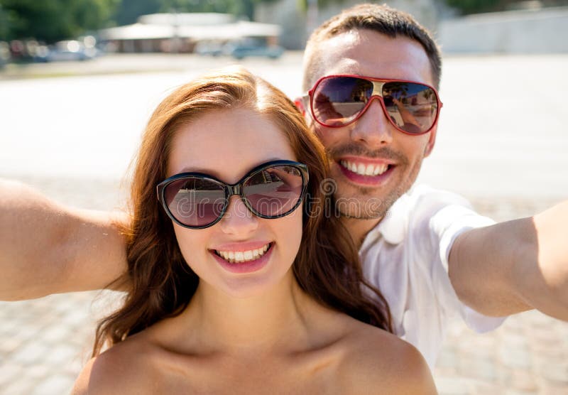 Smiling couple wearing sunglasses making selfie stock photos Smiling couple wearing sunglasses making selfie stock photos