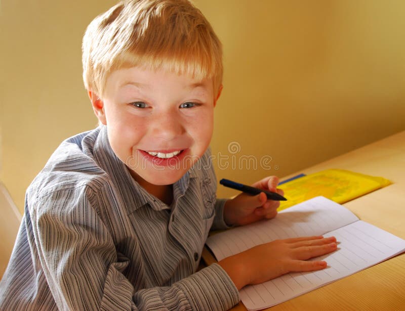 Carino ragazzo Fare il suo compiti a casa, sulla sinistra mano.