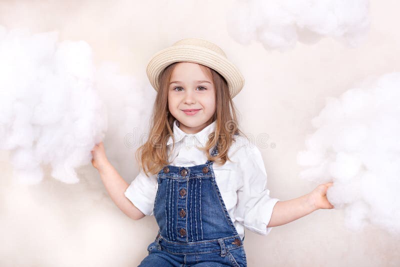 A smiling cute little girl flies in the sky with clouds and stars. Little astrologer Little traveler. The concept of preschool edu royalty free stock images A smiling cute little girl flies in the sky with clouds and stars. Little astrologer Little traveler. The concept of preschool edu royalty free stock images