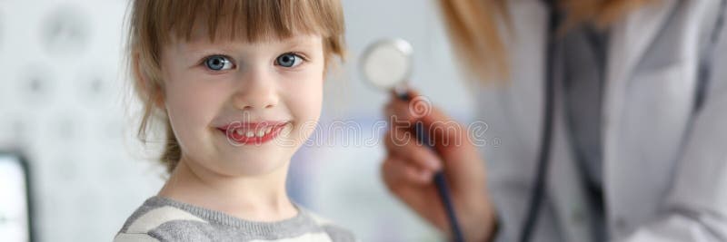 Smiling cute little patient interacting with female doctor stock photo Smiling cute little patient interacting with female doctor stock photo