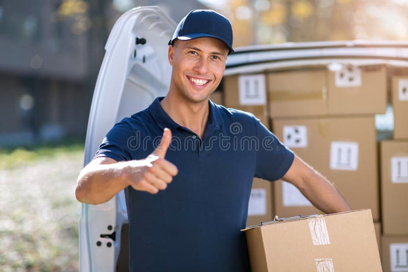 Smiling delivery man loading boxes into his truck stock photos